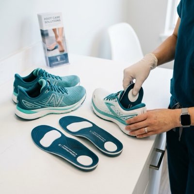 Podiatrist fitting custom prescription orthotics and running shoes for biomechanical correction